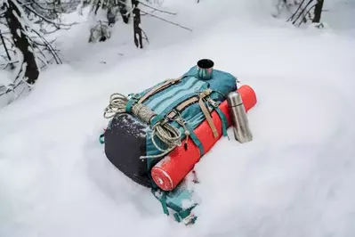 a backpack with camping gear in the snow