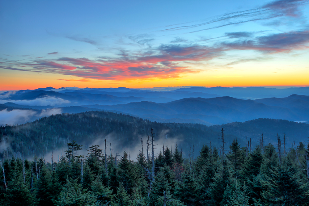 view of sunrise over misty mountains from top of Kuwohi